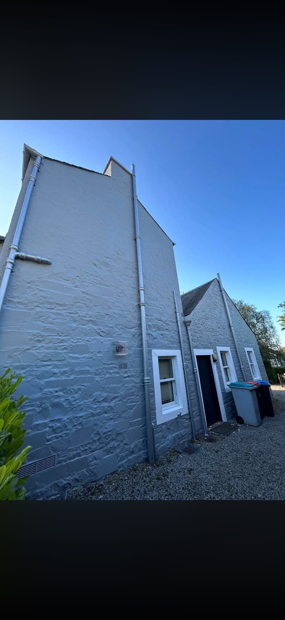 Decorator applying a breathable masonry coating to a rendered exterior wall